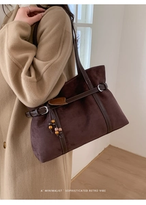Detail of dark brown tote bag featuring suede texture and decorative beaded tassel