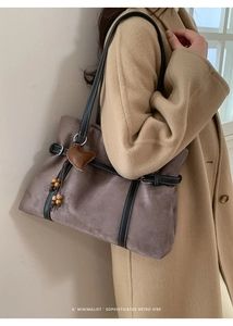 Detail of retro suede tote bag featuring contrast stitching and wooden bead charm