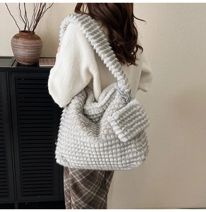 Detail of grey faux fur tote bag with plush grid texture and matching coin purse