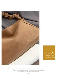 Detail of soft caramel faux leather texture and pleated handle on the shoulder bag