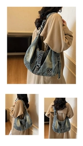 Detail of vintage washed denim hobo bag featuring decorative metal studs and moon shape