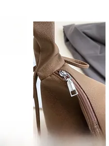 Close-up of smooth silver metal zipper on premium brown lychee textured leather bag