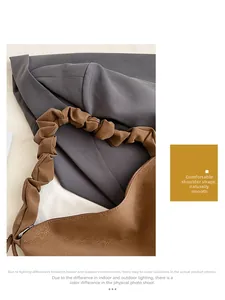 Close-up of caramel brown pebble leather tote bag with pleated cloud shoulder strap