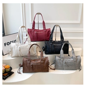 Detailed row of oversized tote bags in five colors with woven straps and rivet details