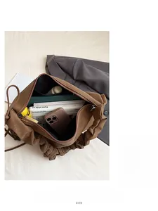 Top view of spacious brown tote bag interior with books, phone and inner pocket detail