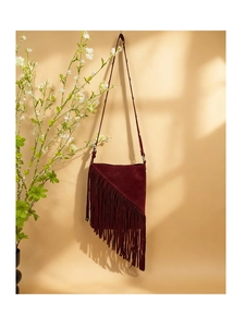 Detail of burgundy faux suede fringe bucket bag with stylish long shoulder straps