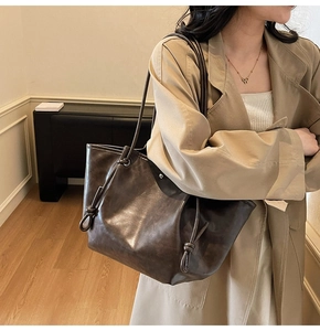 Close-up of dark brown vintage faux leather tote bag with unique knotted strap detail