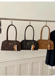 Detailansicht der Retro-Handtaschen in Braun und Schwarz mit Holzperlenanhängern