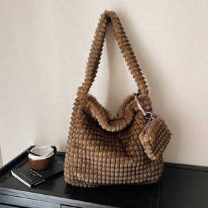 Brown faux fur pleated cloud shoulder bag with matching coin purse in a cozy setting