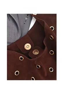 Detail view of premium golden magnetic buckles on brown suede tote bag with metal eyelets
