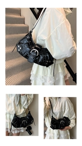 Detail of black faux crocodile leather shoulder bag with silver rivets and buckle