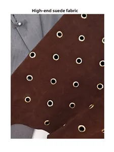 Detailed macro view of premium dark brown suede texture with metallic gold grommets