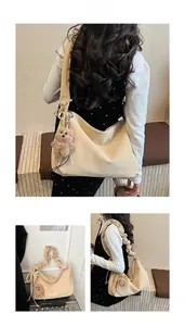 Beige tote bag with pleated straps and teddy bear charm shown from multiple angles