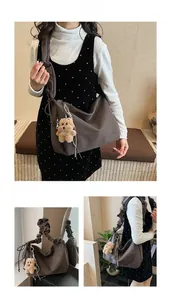 Detail of dark brown tote bag with pleated cloud shoulder strap and bear charm