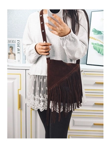 Mirror selfie showing the medium-sized dark brown suede bucket bag with long bohemian fringe