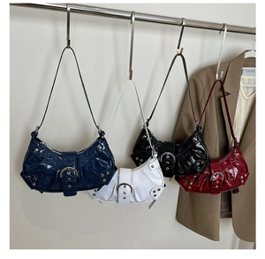 Detail of studded underarm bags in navy, white, black, and burgundy with crocodile pattern