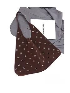 Detail of dark brown suede hobo bag featuring gold grommet eyelets and spacious design