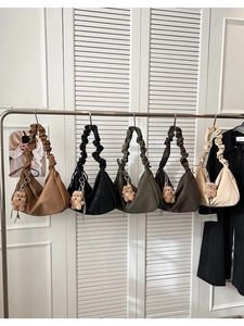 Display of ruched crescent tote bags in five colors with cute plush bear charms