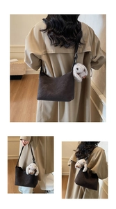 Detail of dark brown matte leather hobo bag with a cute white plush bunny charm