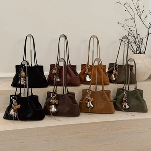 Detail of four retro tote bags in suede finish with leopard heart charms and long handles