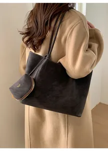 Detalle de bolso tote de ante gris oscuro con estuche de cremallera a juego y logo
