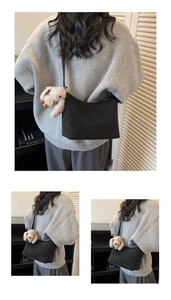 Close-up of black matte shoulder bag with plush bunny charm and smooth texture detail
