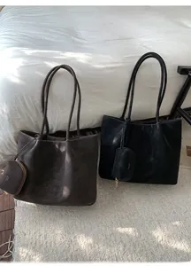Detalle del bolso tote de ante con logo de marca y costuras de alta precisión