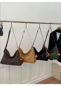 Detalle de bolsos hobo grandes de ante sintético en cuatro colores con costuras y borlas