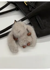 Détail du charm lapin en peluche grise avec pattes en cuir et crochet en métal doré