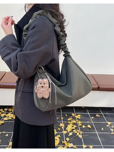 Detail of dark olive pleated crescent tote bag with cute teddy bear pearl pendant