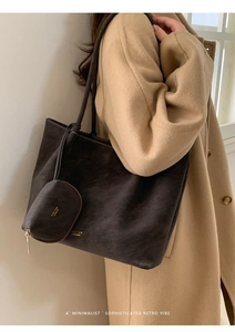 Detalle del bolso tote de ante marrón oscuro y mini bolso a juego sobre abrigo camel