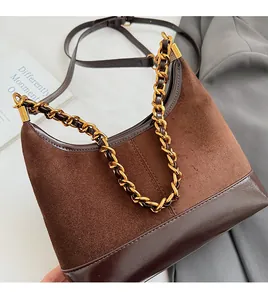 Detail of vintage brown hobo bag with frosted texture and bold gold chain handle