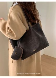 Detalle del bolso tote grande color carbón con logotipo y un pequeño bolso a juego incluido