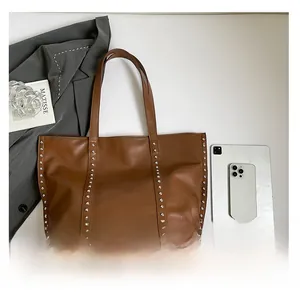 Brown leather tote bag showing spacious interior compared to a tablet and phone