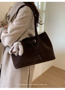 Détail du sac cabas en daim marron foncé avec boucle métallique et breloque lapin en peluche