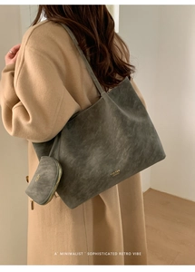 Detalle del bolso tote de ante gris con bolsa con cremallera llevado con abrigo camel