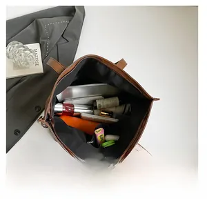 Top view of large brown tote bag showing interior space with laptop and cosmetics