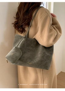 Bolso tote de ante gris-verde con neceser a juego mostrado al hombro de una modelo