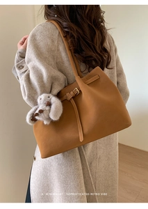 Détail du sac cabas rétro camel avec boucle dorée et breloque lapin en peluche porté