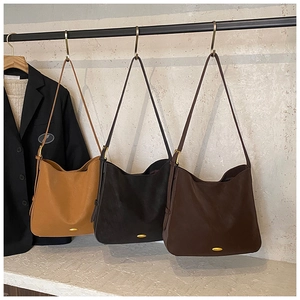 Close-up of matte leather tote bags in camel, black, and coffee with gold metal buckle