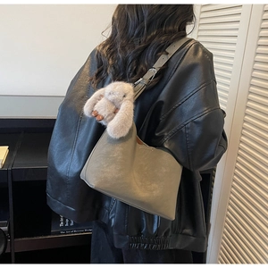 Dettaglio della borsa tote in pelle grigia con ciondolo a forma di coniglio di peluche