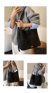 Detail of adjustable metal buckle and golden oval hardware on black suede hobo bag