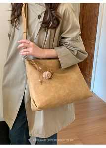 Bolso tote retro de gamuza caqui en modelo, muestra gran capacidad y textura suave