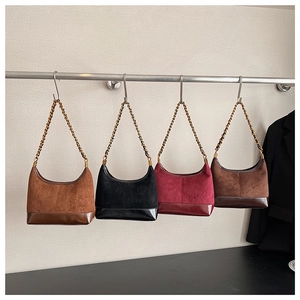 Detail of four vintage frosted chain underarm bags in brown, black, and burgundy hues