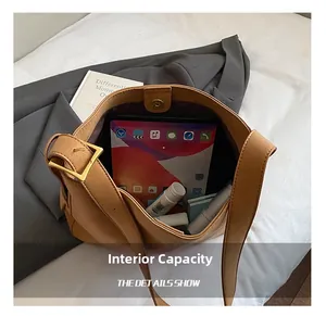 Spacious interior of brown leather tote bag holding a tablet and cosmetics