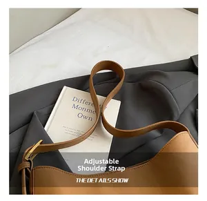 Close-up of the adjustable brown leather strap with golden buckle on minimalist tote bag