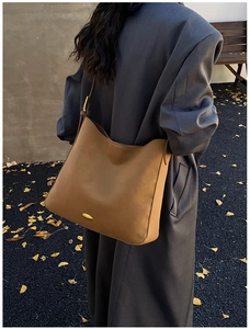 Brown leather hobo bag shoulder view showing large capacity and adjustable strap