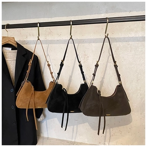 Detailed view of suede hobo bags with fringe tassels and vintage brass hardware