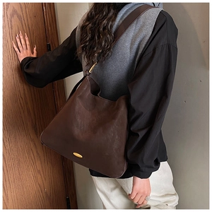 Detail view of large dark brown hobo bag with vintage matte finish and gold hardware logo