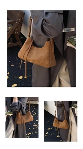 Detailed view of a brown suede hobo bag with stylish tassels and metallic logo accents